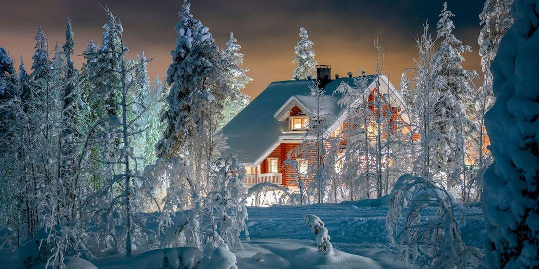 Cabañas nevadas en Laponia al atardecer